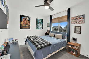 Carpeted bedroom featuring ceiling fan