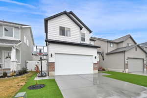 View of front facade featuring a front lawn and a garage