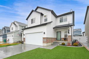 View of front of property with a garage and a front yard