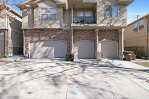 View of front of property with a garage and a balcony