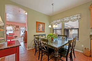 Dining space with a textured ceiling, an inviting chandelier, and tile patterned flooring