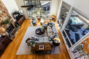 Living room featuring ceiling fan, hardwood / wood-style floors, and a fireplace