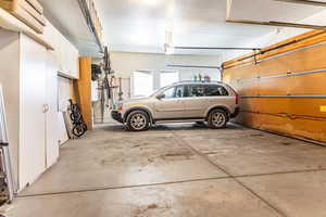 Garage featuring a wall unit AC and a garage door opener