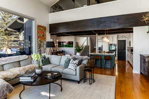 Living room featuring dark wood-type flooring and high vaulted ceiling