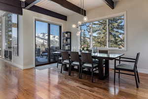 Dining space with hardwood / wood-style floors, a mountain view, beamed ceiling, and plenty of natural light