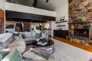 Living room with a high ceiling, hardwood / wood-style floors, and a fireplace