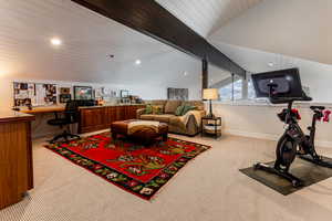 Office space with wooden ceiling, light colored carpet, lofted ceiling, and built in desk