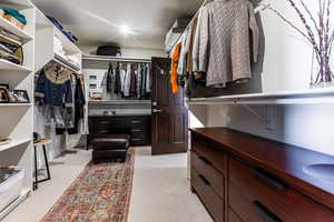 Walk in closet with light colored carpet