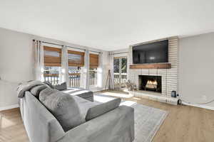 Living room featuring a brick fireplace and light hardwood / wood-style flooring