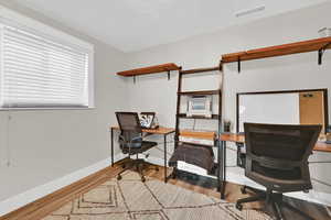 Office area with light hardwood / wood-style floors