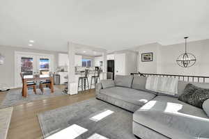 Living room featuring light hardwood / wood-style floors, french doors, and an inviting chandelier