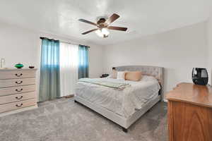 Carpeted bedroom featuring ceiling fan