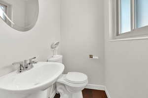 Bathroom with toilet, wood-type flooring, and sink