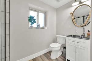 Bathroom with toilet, hardwood / wood-style flooring, and vanity