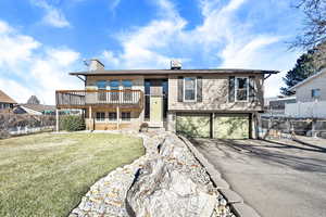 View of front of house featuring a front lawn and a garage