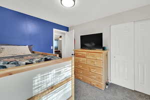 Carpeted bedroom featuring a closet