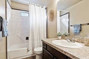 Full bathroom with toilet, vanity, shower / bathtub combination with curtain, and tile patterned flooring