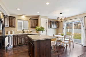 Kitchen featuring sink, a center island, dark hardwood / wood-style floors, and pendant lighting