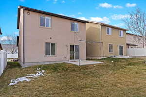 Rear view of house with a patio and a lawn