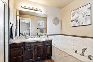 Bathroom featuring vanity and a relaxing tiled tub