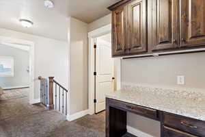 Kitchen with dark brown cabinets and dark carpet