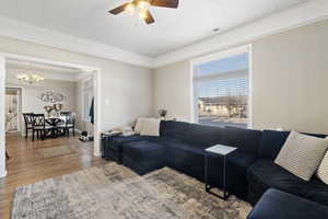 Living room with hardwood / wood-style floors and ceiling fan with notable chandelierMAIN HOME