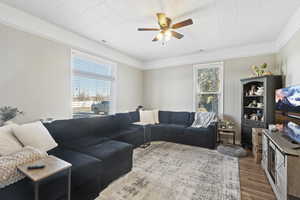 Living room with wood walls, hardwood / wood-style floors, and ceiling fan MAIN HOME