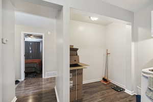 Clothes washing area with dark hardwood / wood-style floors ADU