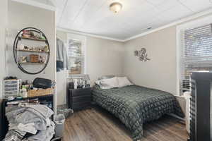 Bedroom with hardwood / wood-style floors, crown molding, and multiple windows MAIN HOME