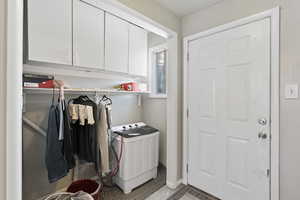 Clothes washing area featuring cabinets, tile patterned floors, and washer / clothes dryer ADU