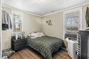 Bedroom featuring wood-type flooring and ornamental molding