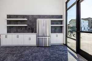 Club House Kitchen featuring sink, white cabinets, and stainless steel refrigerator