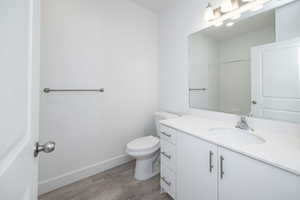 Main Full Bathroom featuring wood-type flooring, toilet, and vanity