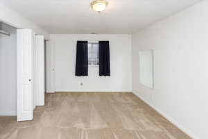 Unfurnished bedroom featuring light carpet