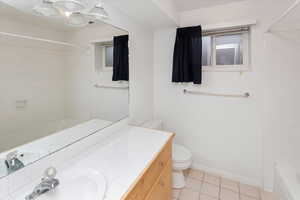 Full bathroom featuring toilet, a chandelier, tile patterned floors, vanity, and tiled shower / bath