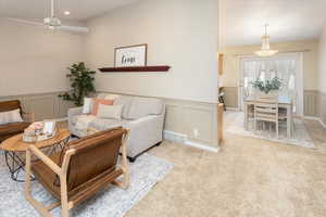 Living room with vaulted ceiling and light colored carpet