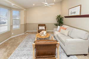 Carpeted living room featuring vaulted ceiling and ceiling fan