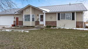 View of front of property featuring a garage and a front yard