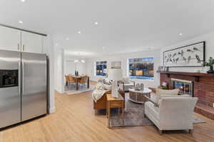 Living room with a fireplace, a chandelier, and light hardwood / wood-style flooring