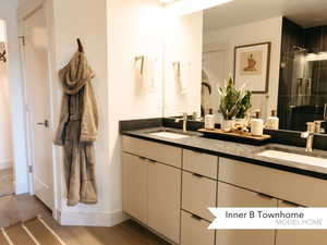 Bathroom with hardwood / wood-style flooring, an enclosed shower, and vanity