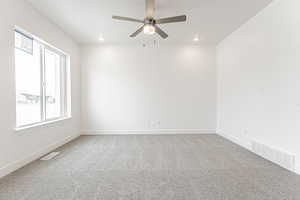 Carpeted spare room featuring recessed lighting, visible vents, ceiling fan, and baseboards