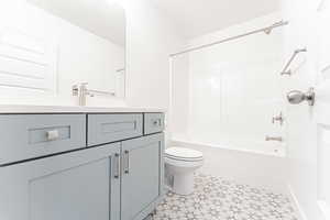 Bathroom with bathing tub / shower combination, toilet, and vanity