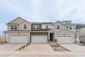 View of front of house featuring board and batten siding, an attached garage, and concrete driveway