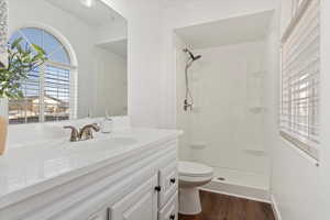 Bathroom featuring toilet, hardwood / wood-style flooring, a shower, and vanity