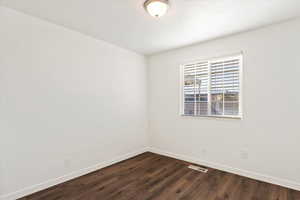 Empty room with dark wood-type flooring