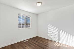 Unfurnished room with dark hardwood / wood-style floors