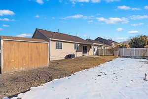 Snow covered house featuring cooling unit