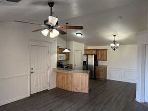 Kitchen with kitchen peninsula, sink, dark hardwood / wood-style floors, lofted ceiling, and stainless steel appliances