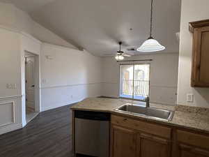 Kitchen featuring dishwasher, hanging light fixtures, sink, dark hardwood / wood-style flooring, and lofted ceiling