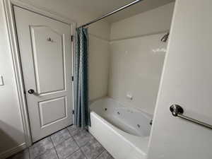 Bathroom featuring shower / bath combo with shower curtain and tile patterned floors